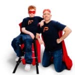 Paul sitzt auf einem Hocker uns stützt seinen Arm auf Papa. Beide schauen in die Kamera - papaundpaul.de